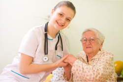 nurse holding an old woman's hand
